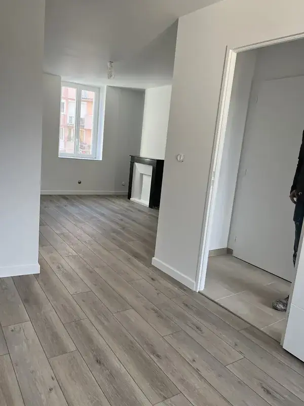 Exemple d'intérieur rénové avec murs clairs, parquet gris et rendu lumineux