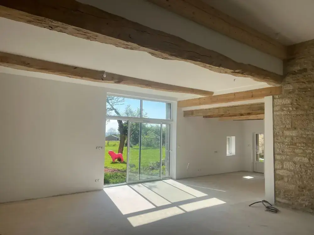 Rénovation intérieure grange avec plâtrerie et béton ciré dans le Jura